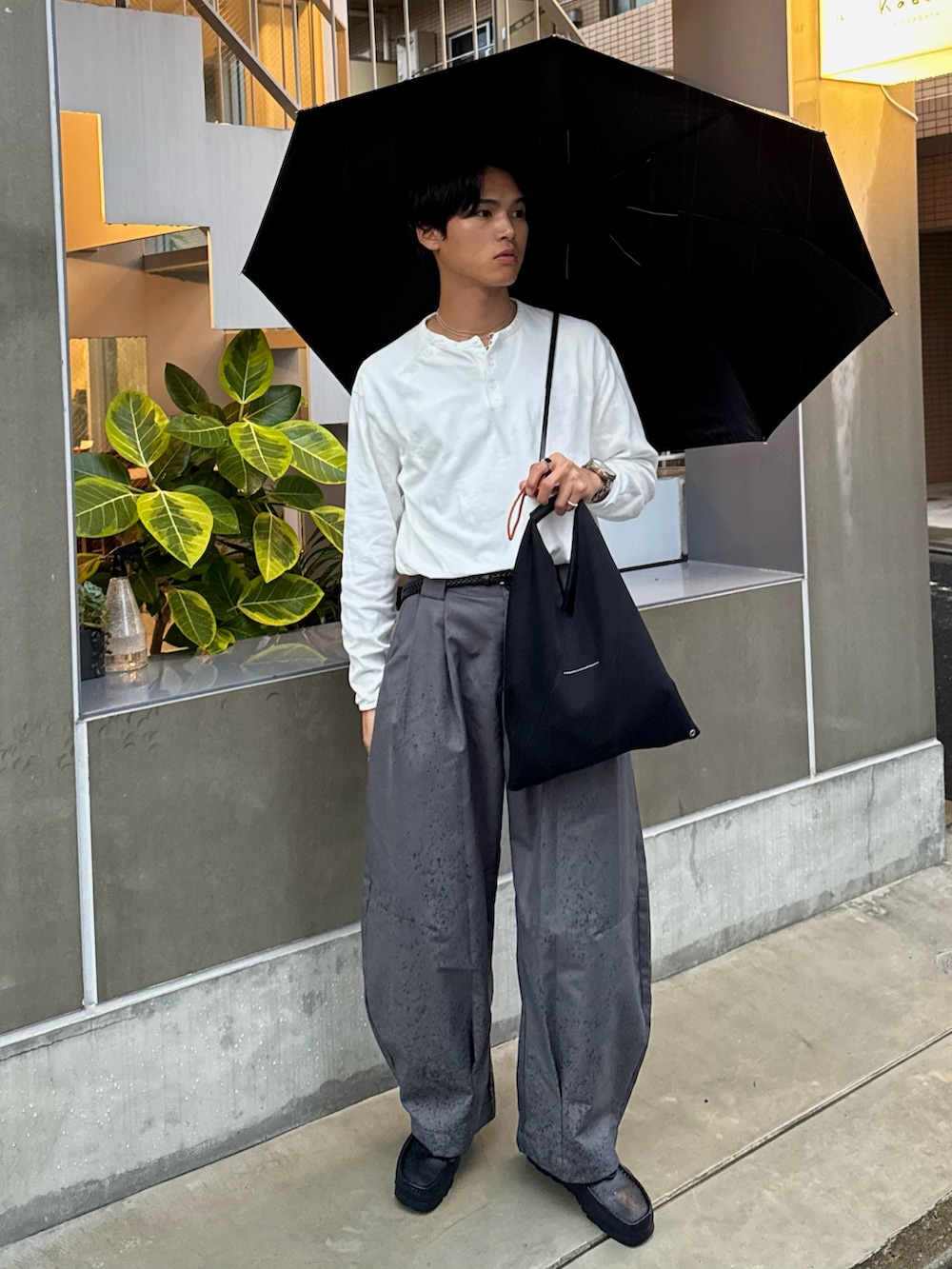 ホワイト系のTシャツ/カットソー、ブラック系のハンドバッグ、ブラック系のモカシン/デッキシューズを着用したメンズの秋コーディネートの5枚目の写真