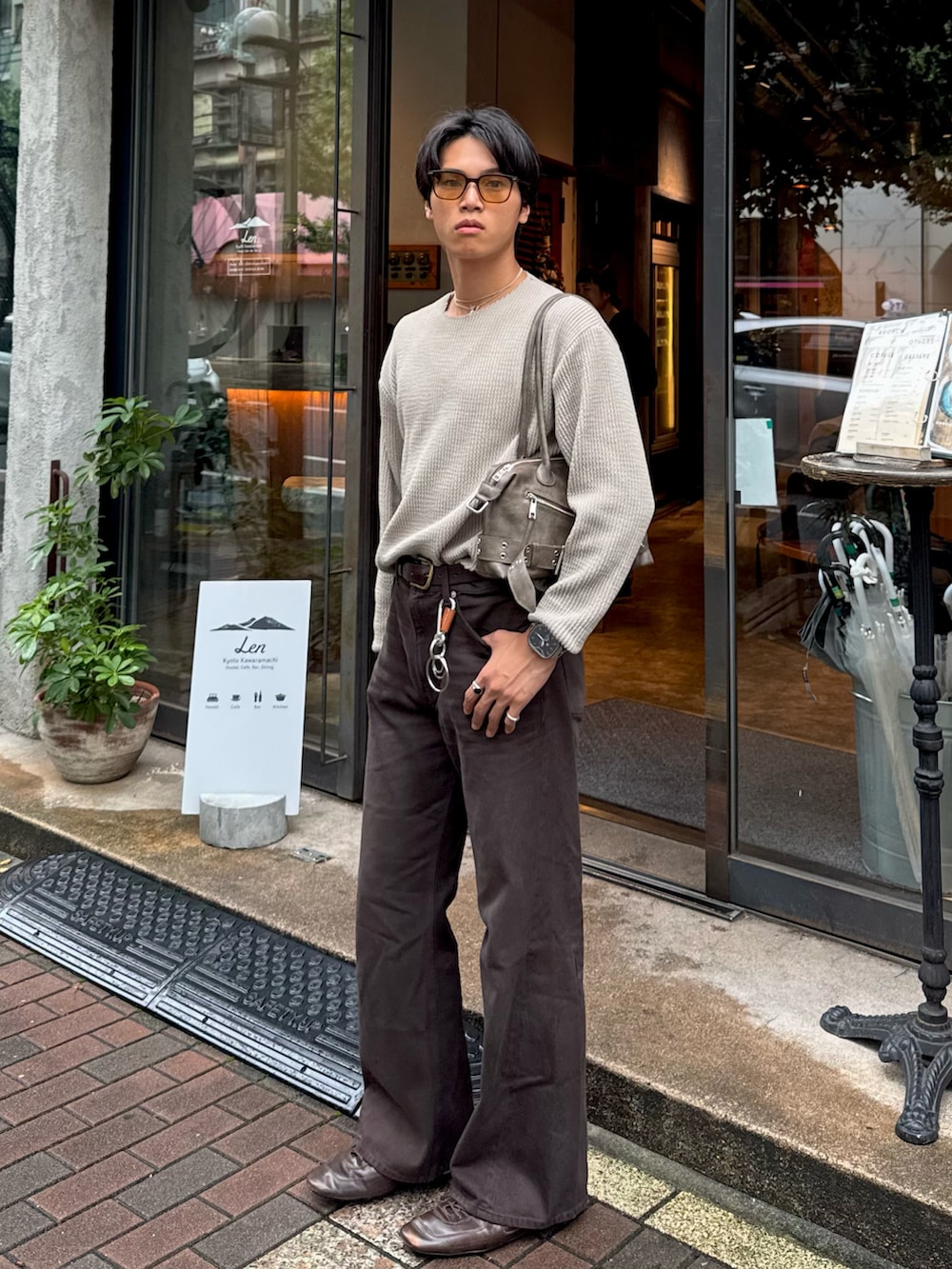 グリーン系のTシャツ/カットソー、ブラウン系のデニムパンツ、ブラウン系のショルダーバッグを着用したメンズの秋コーディネートの5枚目の写真