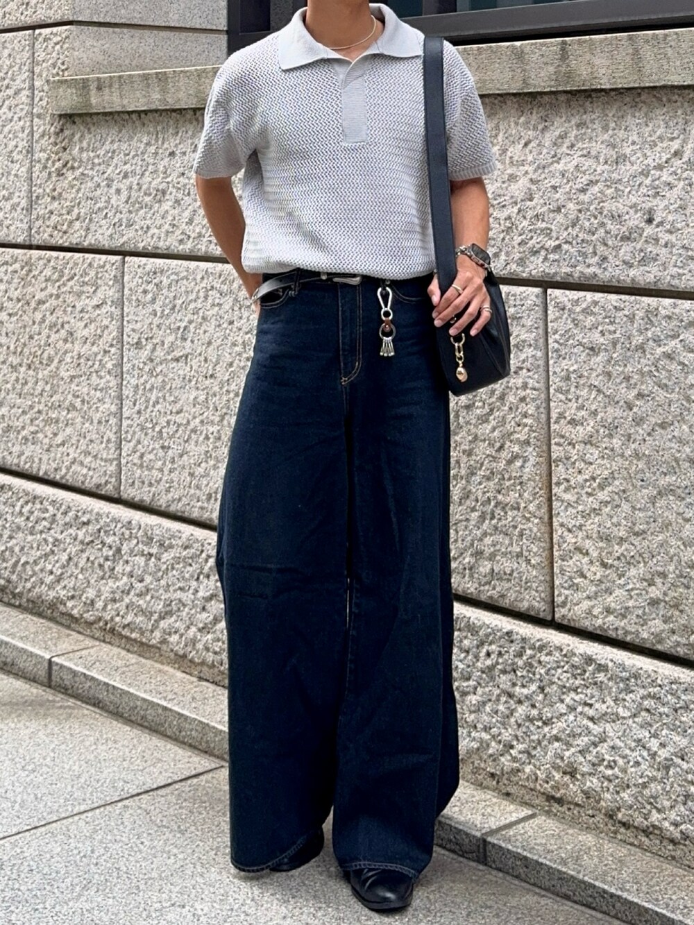 グレー系のポロシャツ、ブルー系のデニムパンツ、ブラック系のハンドバッグを着用したメンズの夏コーディネートの4枚目の写真