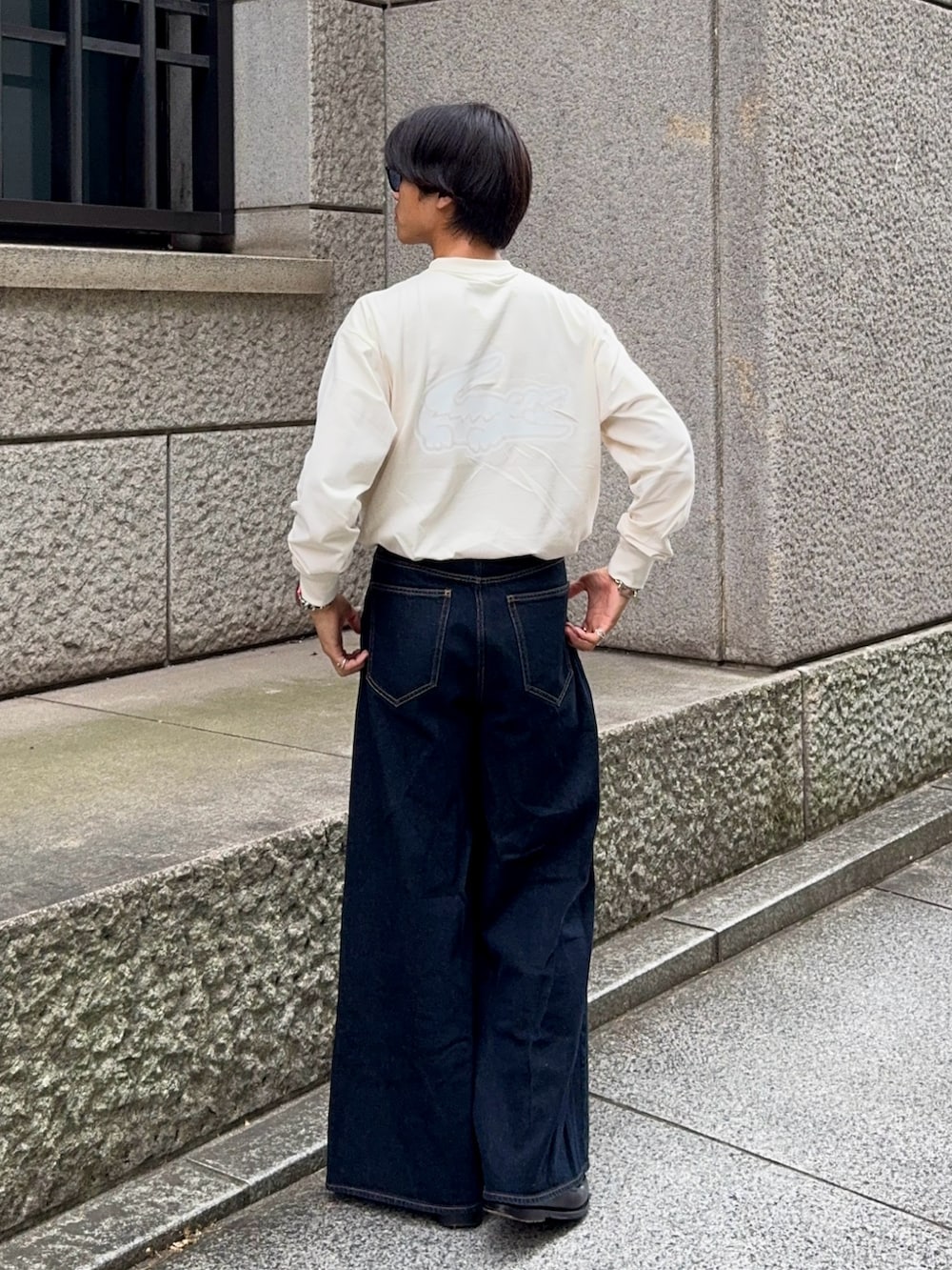 ベージュ系のTシャツ/カットソー、ブラック系のローファー、ブルー系のデニムパンツを着用したメンズの秋コーディネートの4枚目の写真