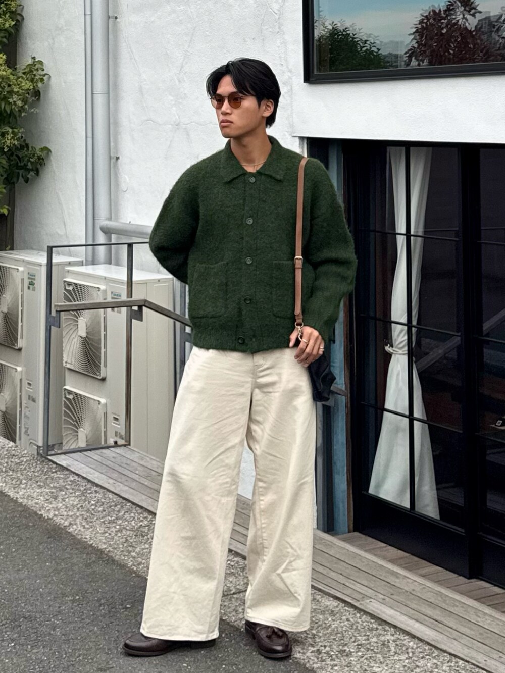 グリーン系のカーディガン/ボレロ、ホワイト系のデニムパンツ、ブラウン系のローファーを着用したメンズの秋コーディネートの5枚目の写真