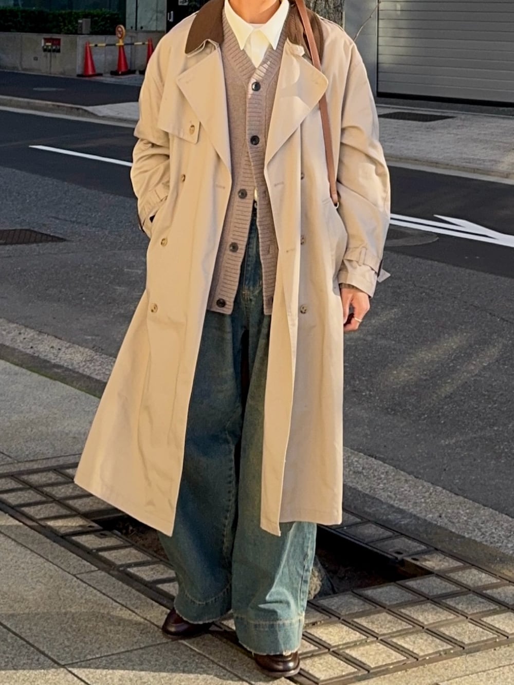 ホワイト系のシャツ/ブラウス、ベージュ系のトレンチコート、ブルー系のデニムパンツを着用したメンズの冬コーディネートの4枚目の写真