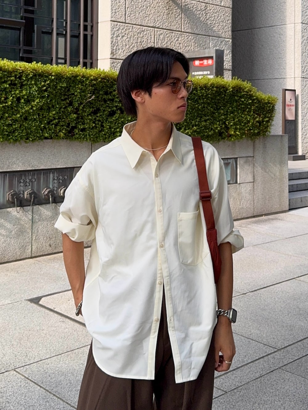 ホワイト系のシャツ/ブラウス、ブラウン系のスラックス、ブラウン系のショルダーバッグを着用したメンズの夏コーディネートの2枚目の写真