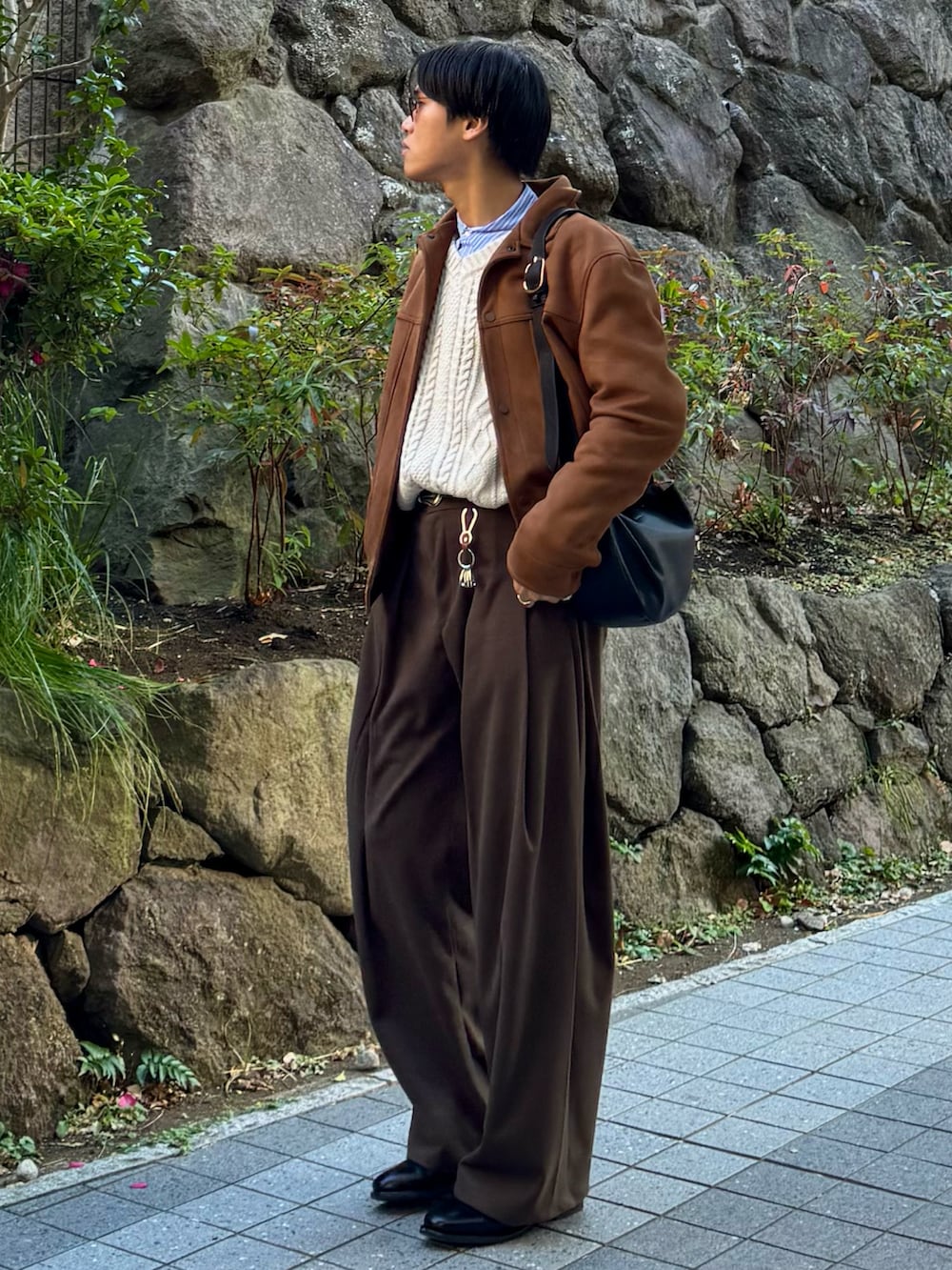 ブラック系のドレスシューズ、ブラウン系のスラックス、ブラック系のハンドバッグを着用したメンズの冬コーディネートの3枚目の写真