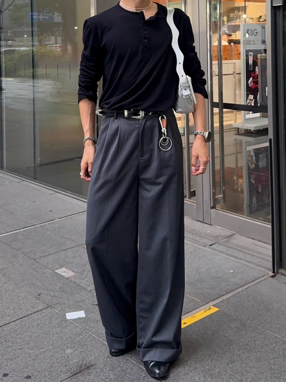 ブラック系のTシャツ/カットソー、グレー系のスラックス、シルバー系のショルダーバッグを着用したメンズの夏コーディネートの4枚目の写真