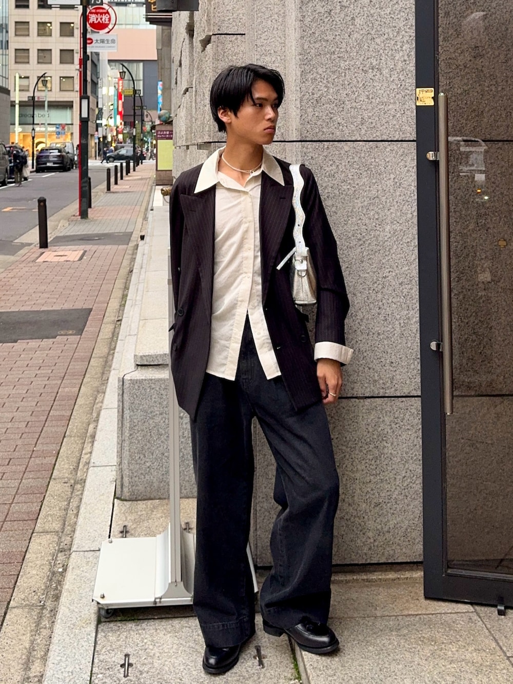 ブラック系のデニムパンツ、その他のテーラードジャケット、ブラック系のローファーを着用したメンズの春コーディネートの5枚目の写真