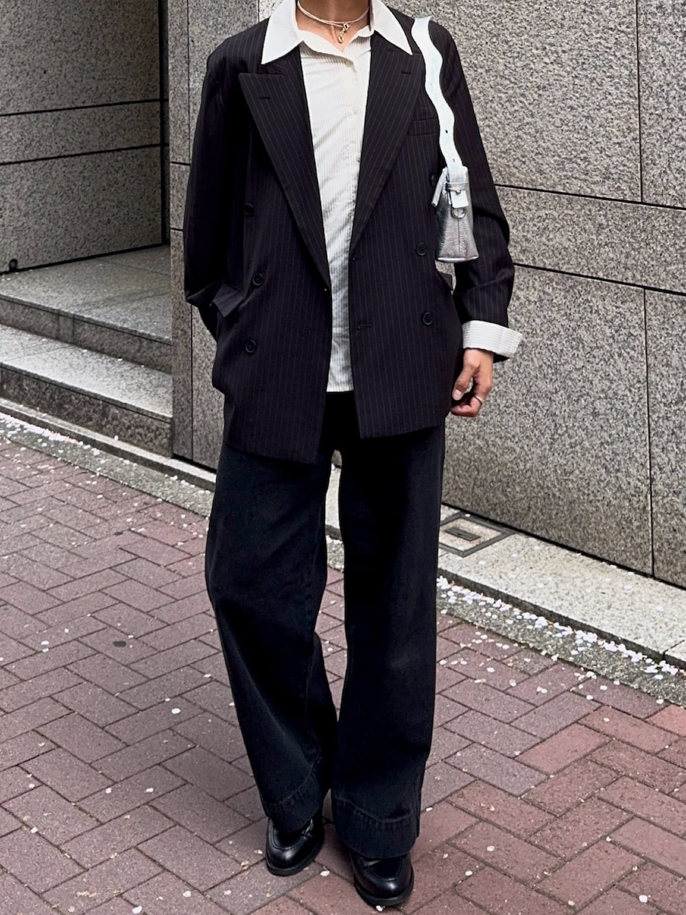 ブラック系のデニムパンツ、その他のテーラードジャケット、ブラック系のローファーを着用したメンズの春コーディネートの4枚目の写真
