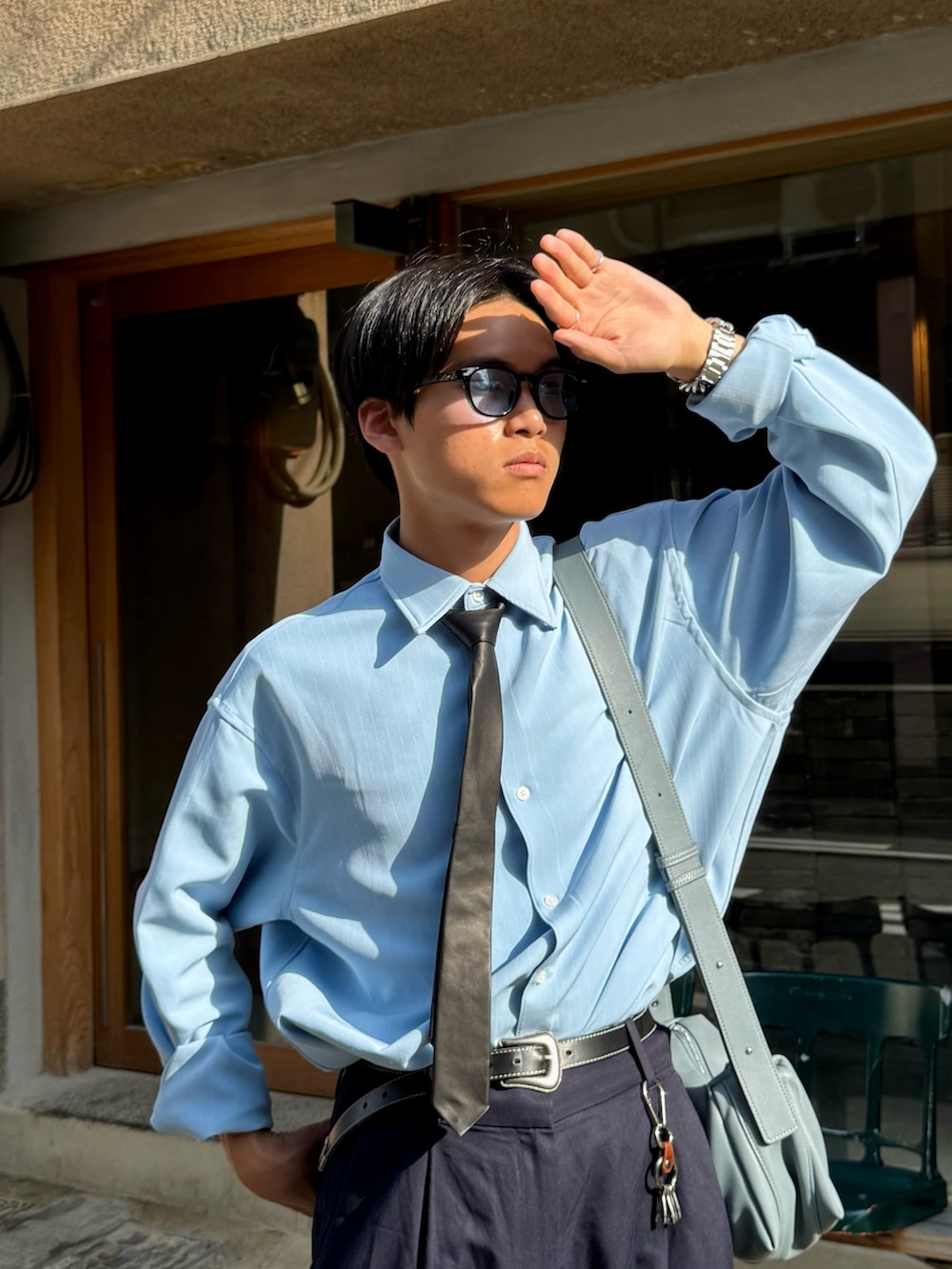 ブルー系のシャツ/ブラウス、ブラック系のネクタイ、ブルー系のショルダーバッグを着用したメンズの春コーディネートの2枚目の写真