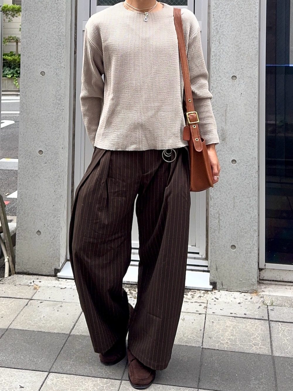 グリーン系のTシャツ/カットソー、ブラウン系のスラックス、ブラウン系のショルダーバッグを着用したメンズの夏コーディネートの4枚目の写真