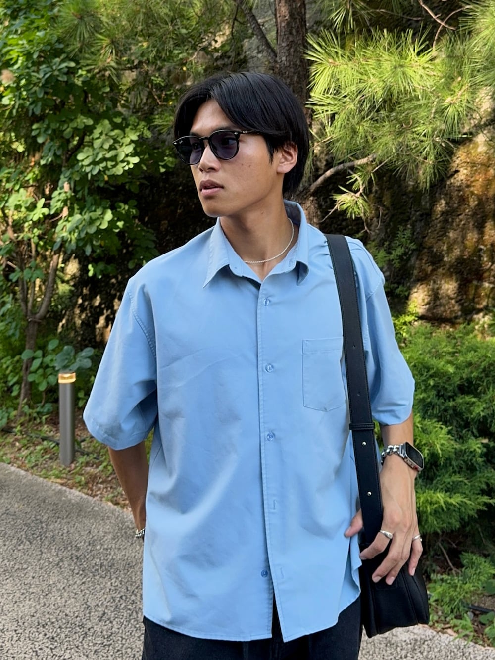 ブルー系のシャツ/ブラウス、ブラック系のデニムパンツ、ブラック系のショルダーバッグを着用したメンズの夏コーディネートの2枚目の写真