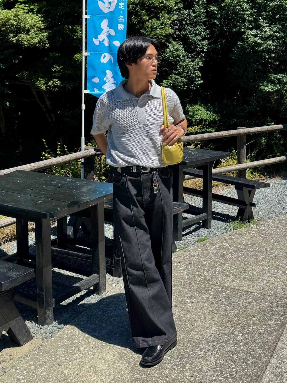 ブラック系のローファー、グレー系のポロシャツ、グリーン系のショルダーバッグを着用したメンズの夏コーディネートの3枚目の写真