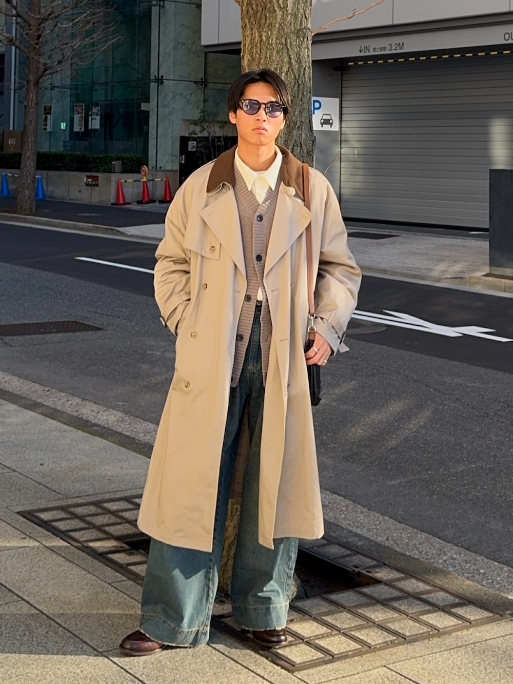 ホワイト系のシャツ/ブラウス、ベージュ系のトレンチコート、ブルー系のデニムパンツを着用したメンズの冬コーディネートの5枚目の写真