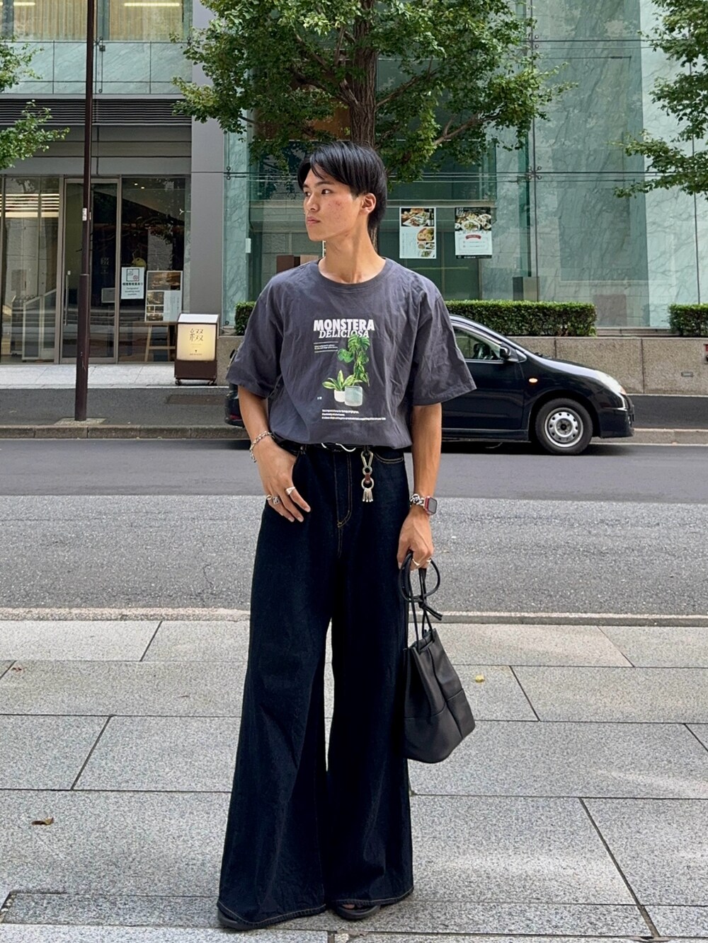 ブラック系のバッグ、ブルー系のデニムパンツ、グレー系のTシャツ/カットソーを着用したメンズの夏コーディネートの3枚目の写真