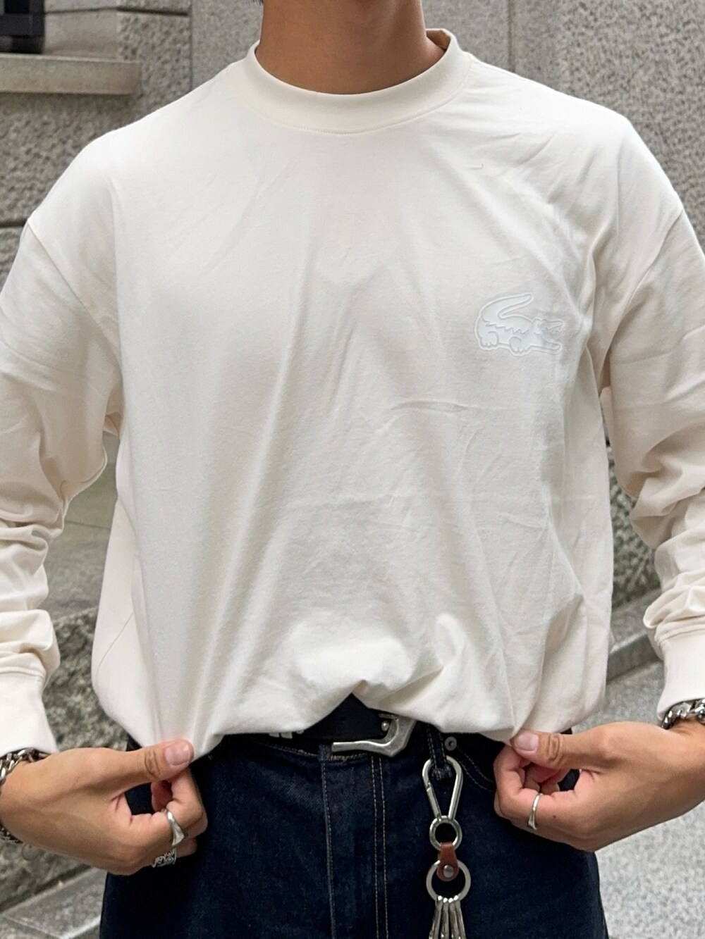 ベージュ系のTシャツ/カットソー、ブラック系のローファー、ブルー系のデニムパンツを着用したメンズの秋コーディネートの3枚目の写真