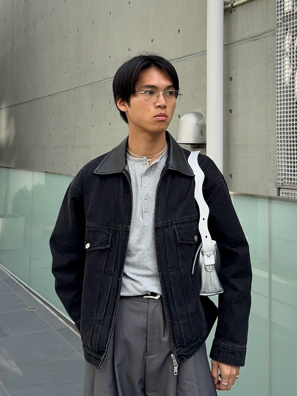 グレー系のTシャツ/カットソー、ブラック系のデニムジャケット、ブラック系のローファーを着用したメンズの春コーディネートの2枚目の写真