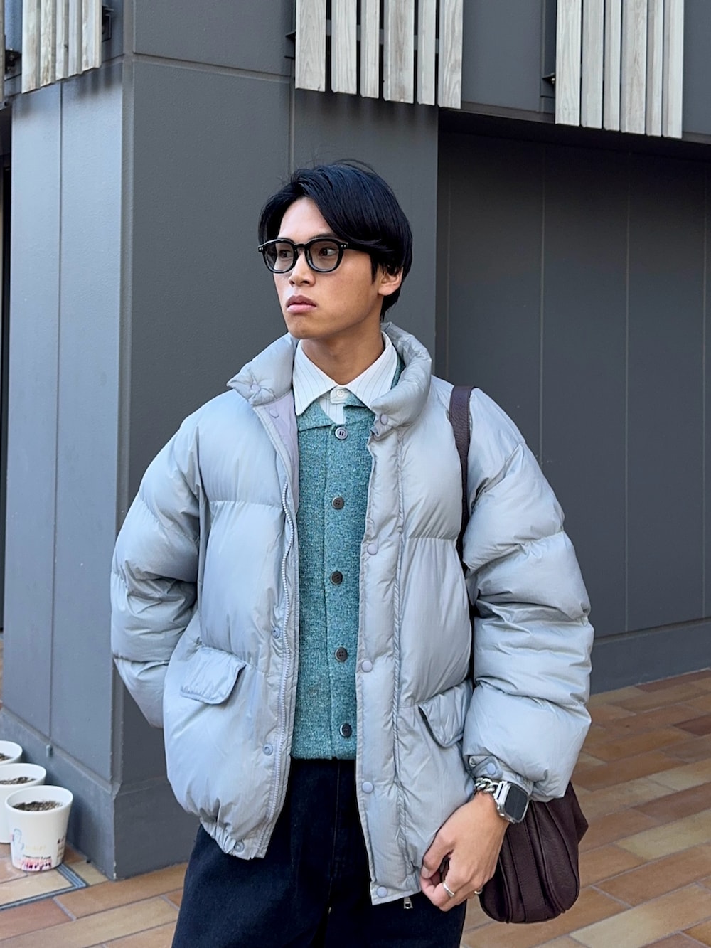 ブラック系のデニムパンツ、ブラウン系のローファー、グレー系のダウンジャケット/コートを着用したメンズの冬コーディネートの2枚目の写真