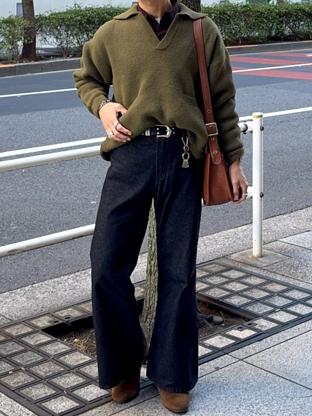 グリーン系のニット/セーター、ブラウン系のシャツ/ブラウス、ブラック系のデニムパンツを着用したメンズの冬コーディネートの4枚目の写真