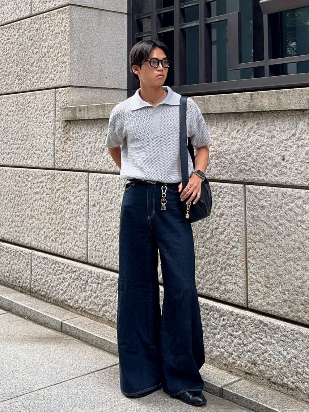グレー系のポロシャツ、ブルー系のデニムパンツ、ブラック系のハンドバッグを着用したメンズの夏コーディネートの5枚目の写真