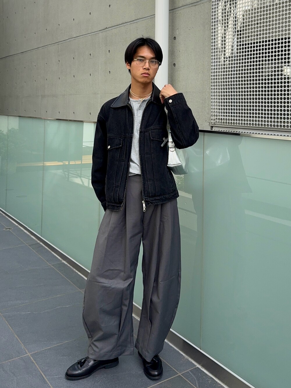 グレー系のTシャツ/カットソー、ブラック系のデニムジャケット、ブラック系のローファーを着用したメンズの春コーディネートの3枚目の写真