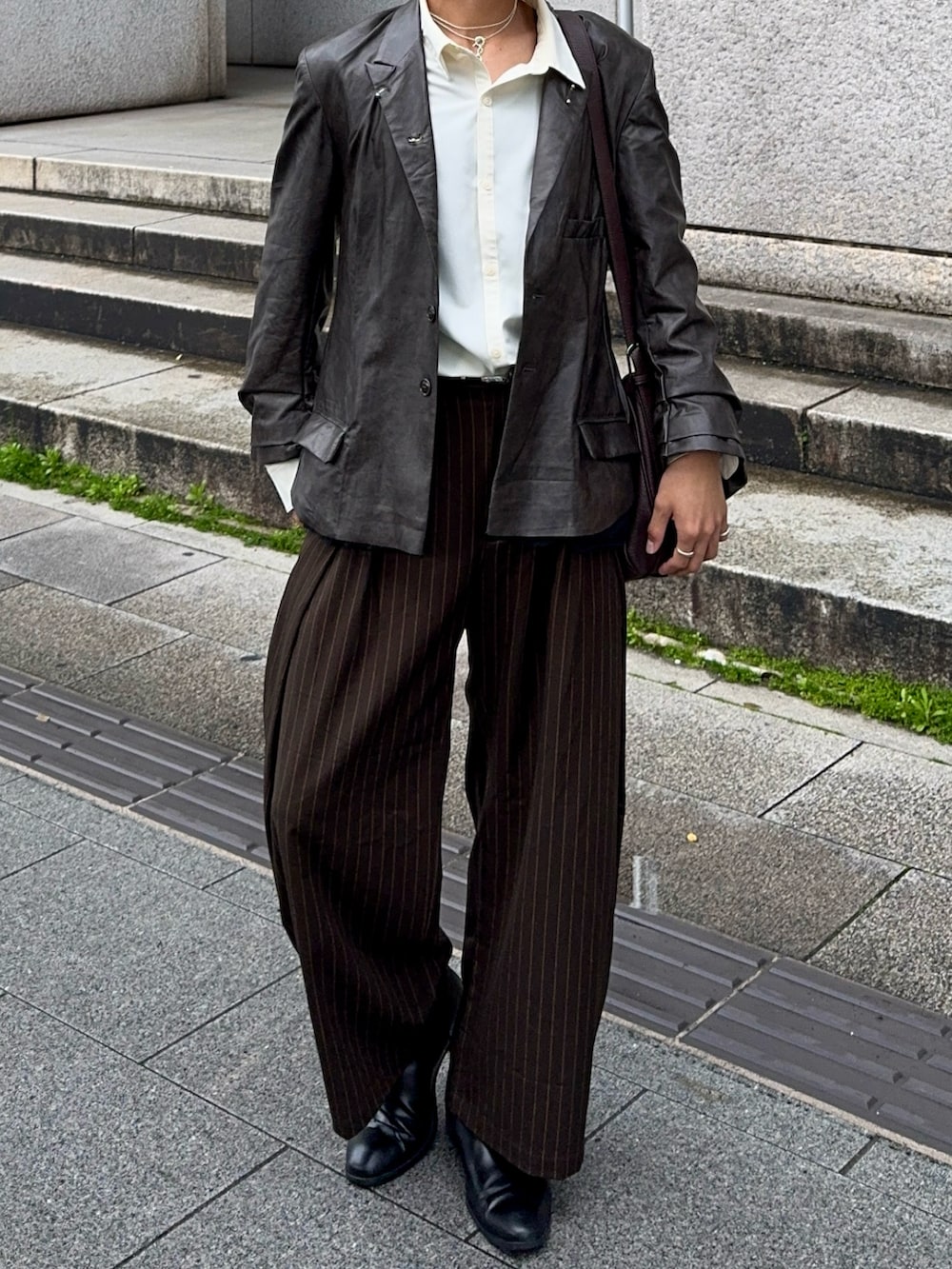 ブラック系のテーラードジャケット、ブラウン系のスラックス、ホワイト系のシャツ/ブラウスを着用したメンズの春コーディネートの4枚目の写真