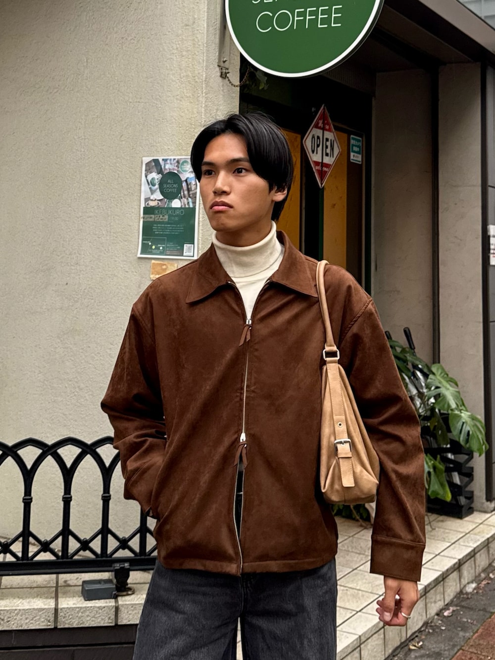 ブラウン系のブルゾン、ブラック系のデニムパンツ、ホワイト系のニット/セーターを着用したメンズの冬コーディネートの2枚目の写真