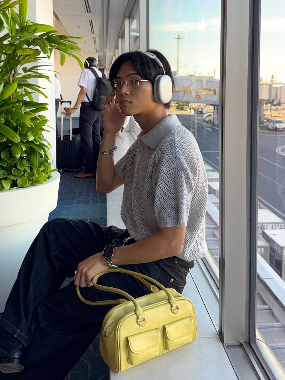 ブラック系のローファー、グレー系のポロシャツ、グリーン系のショルダーバッグを着用したメンズの夏コーディネートの5枚目の写真