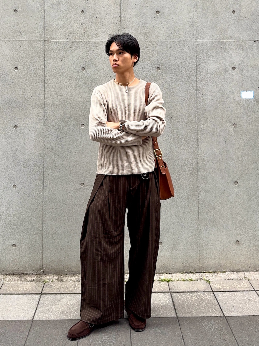 グリーン系のTシャツ/カットソー、ブラウン系のスラックス、ブラウン系のショルダーバッグを着用したメンズの夏コーディネートの3枚目の写真