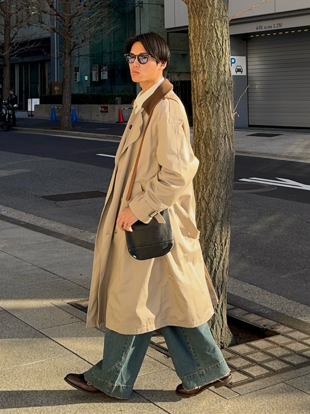 ホワイト系のシャツ/ブラウス、ベージュ系のトレンチコート、ブルー系のデニムパンツを着用したメンズの冬コーディネートの3枚目の写真