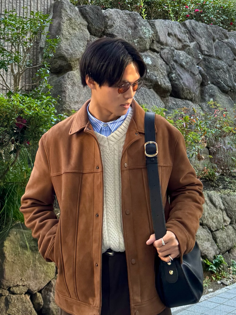 ブラック系のドレスシューズ、ブラウン系のスラックス、ブラック系のハンドバッグを着用したメンズの冬コーディネートの2枚目の写真