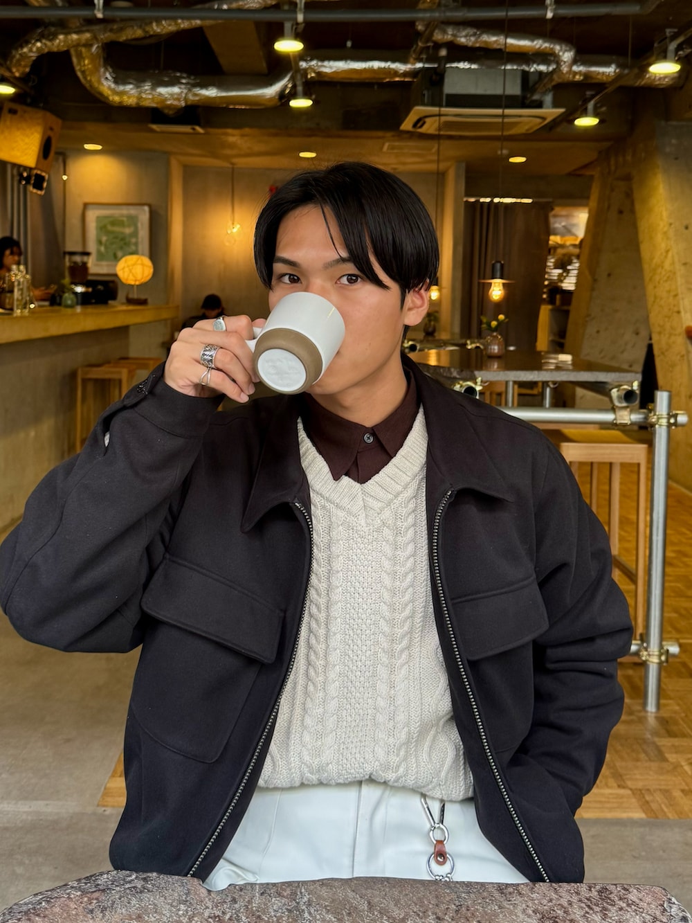 ホワイト系のニット/セーター、ブラウン系のシャツ/ブラウス、ブラック系のローファーを着用したメンズの冬コーディネートの2枚目の写真