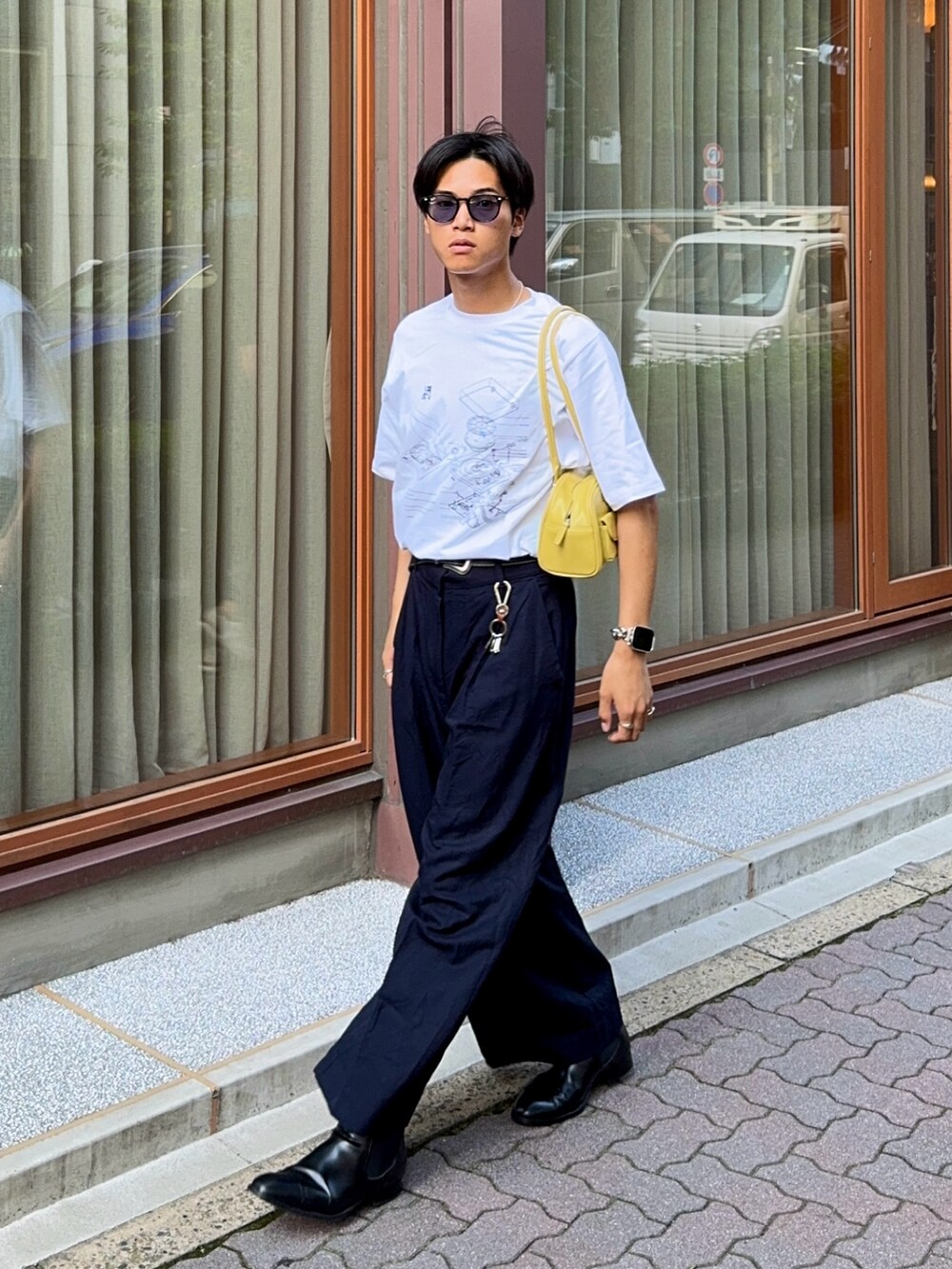 ホワイト系のTシャツ/カットソー、ブルー系のスラックス、ブラック系のブーツを着用したメンズの夏コーディネートの3枚目の写真