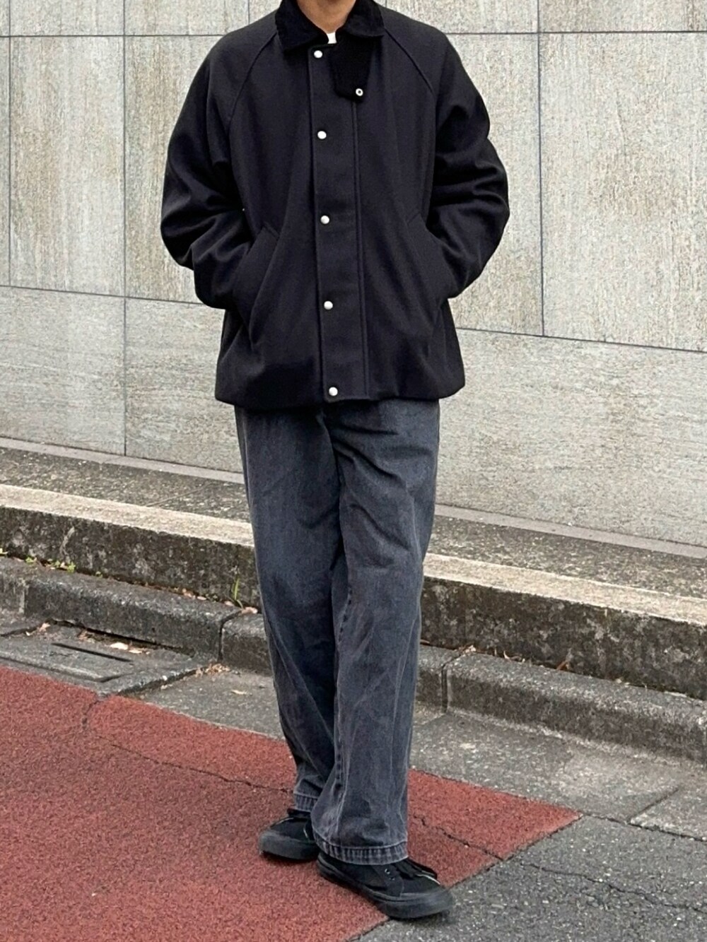 ブラック系のスニーカー、グレー系のデニムパンツ、ブラック系のブルゾンを着用したメンズの冬コーディネートの4枚目の写真