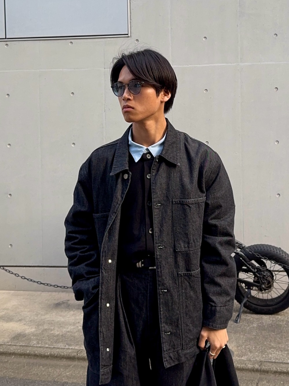 ブラック系のカーディガン/ボレロ、ブルー系のシャツ/ブラウス、ブラック系のハンドバッグを着用したメンズの冬コーディネートの2枚目の写真