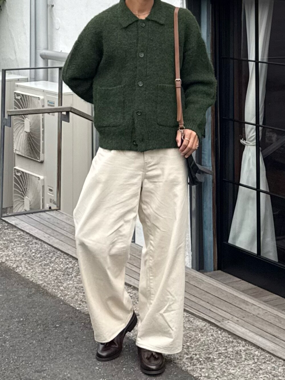 グリーン系のカーディガン/ボレロ、ホワイト系のデニムパンツ、ブラウン系のローファーを着用したメンズの秋コーディネートの4枚目の写真
