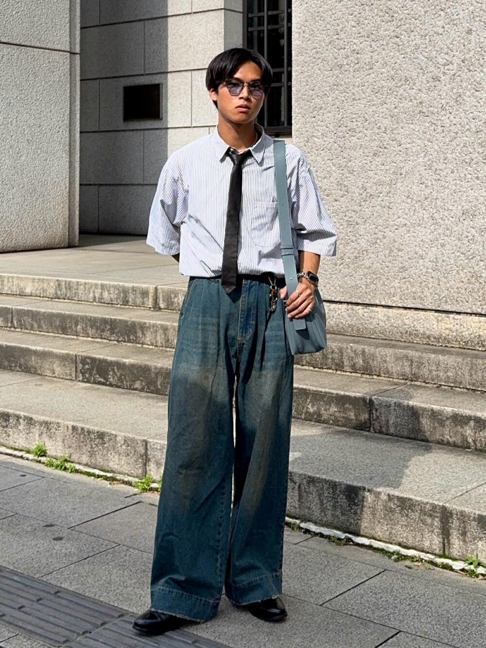 ホワイト系のシャツ/ブラウス、ブルー系のデニムパンツ、ブラック系のドレスシューズを着用したメンズの夏コーディネートの5枚目の写真