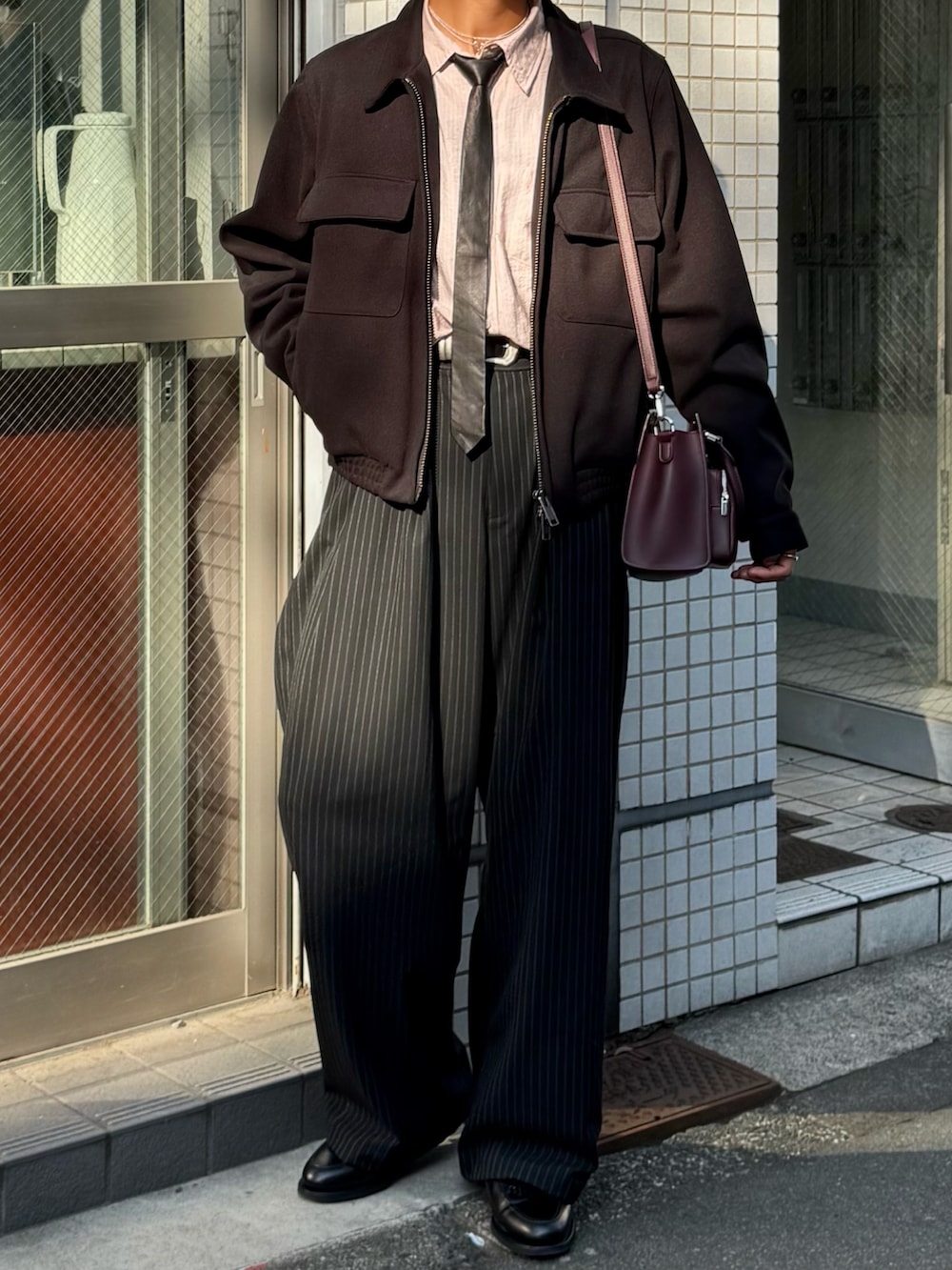 ピンク系のシャツ/ブラウス、その他のスラックス、ブラック系のブルゾンを着用したメンズの春コーディネートの4枚目の写真