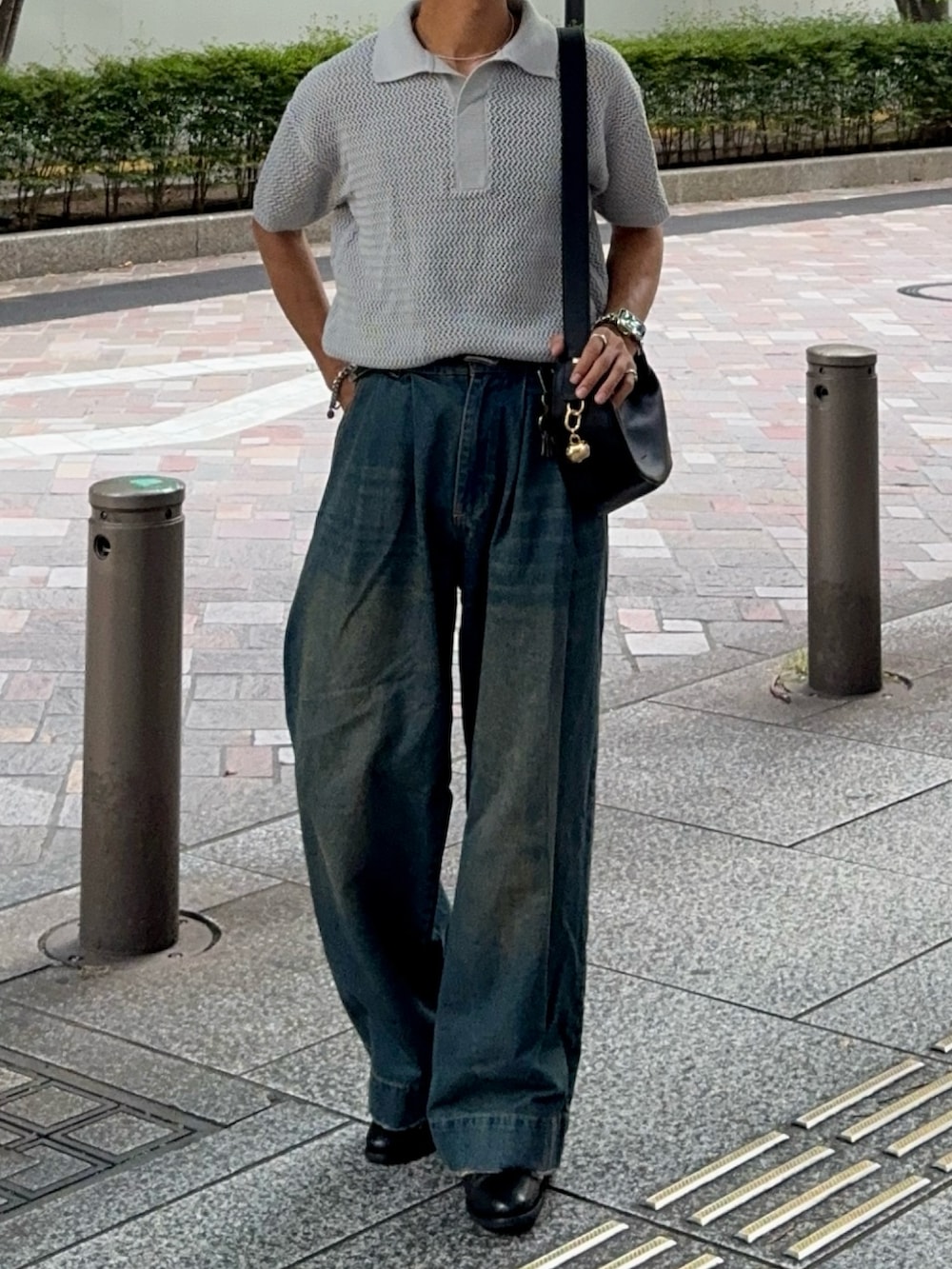 ブルー系のデニムパンツ、ブラック系のハンドバッグ、ブラック系のドレスシューズを着用したメンズの夏コーディネートの4枚目の写真