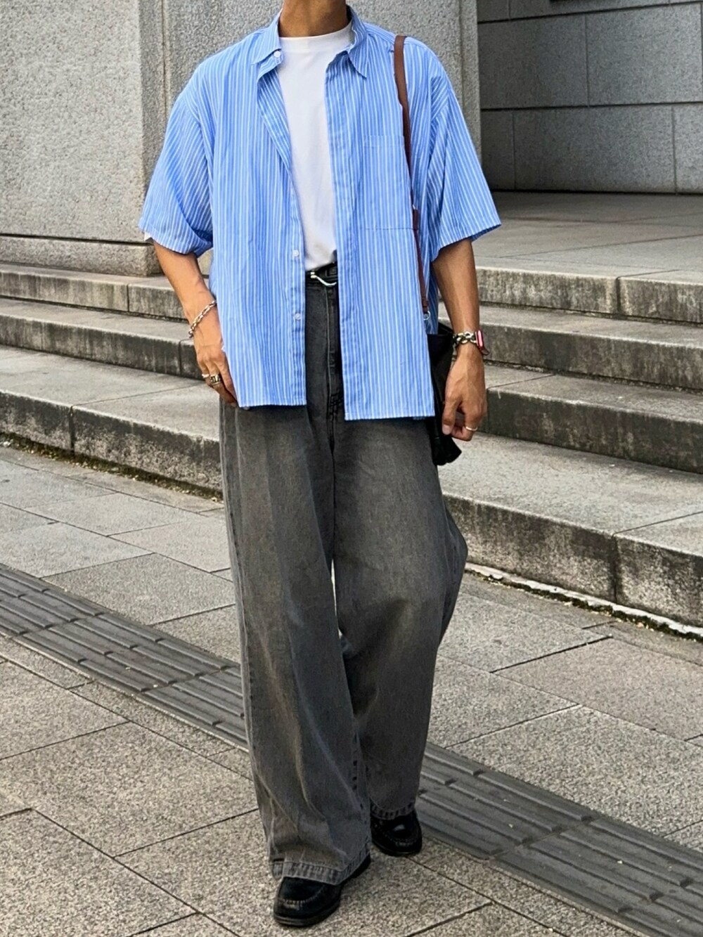 グレー系のデニムパンツ、ブラック系のローファー、ブルー系のシャツ/ブラウスを着用したメンズの夏コーディネートの4枚目の写真