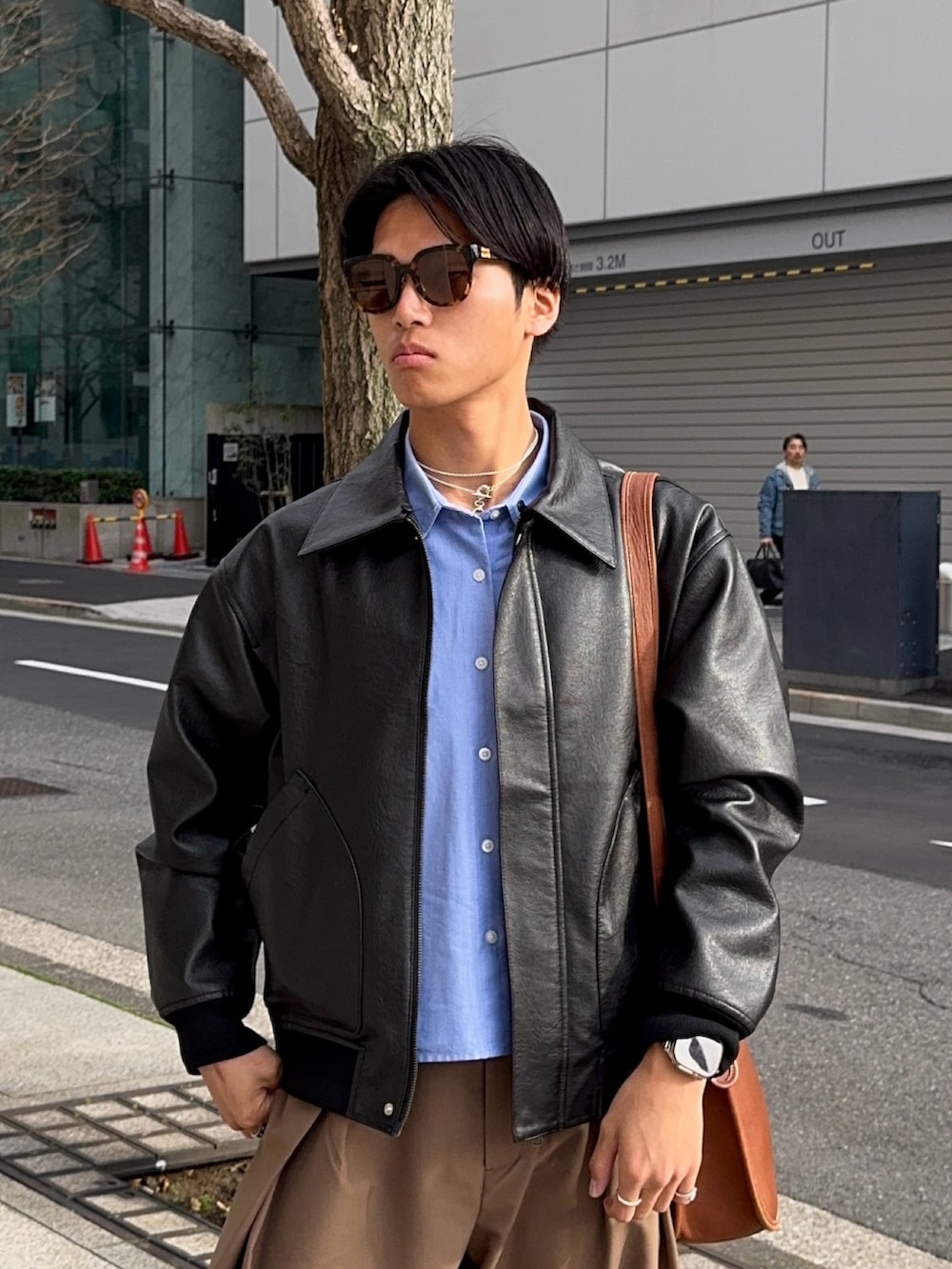 ブラウン系のスラックス、ブラウン系のローファー、ブラック系のその他アウターを着用したメンズの春コーディネートの2枚目の写真