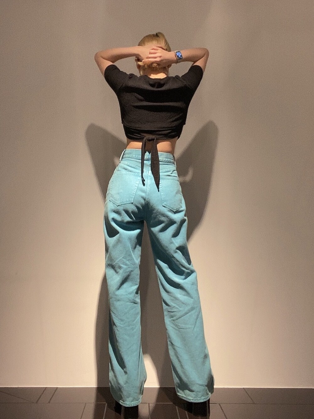 ブラック系のTシャツ/カットソー、グリーン系のデニムパンツ、ブラック系のサンダルを着用したレディースの春コーディネートの3枚目の写真