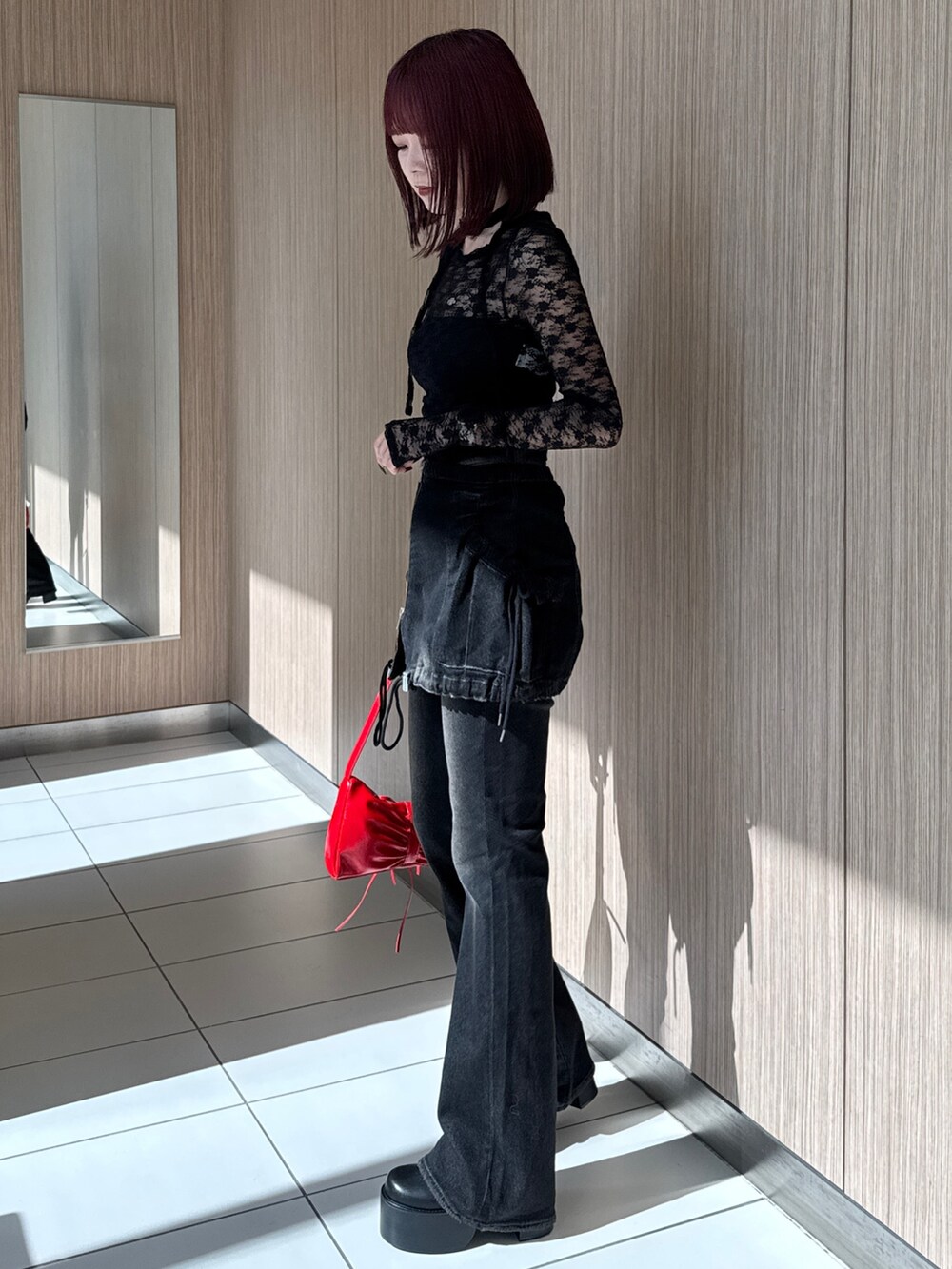 ブラック系のTシャツ/カットソー、ブラック系のデニムパンツ、レッド系のショルダーバッグを着用したレディースの秋コーディネートの4枚目の写真