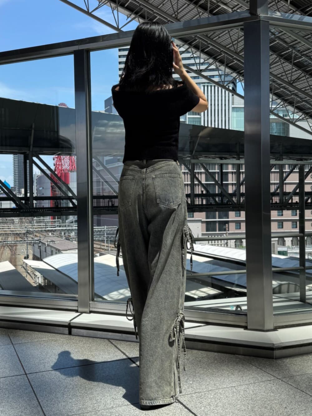 ブラック系のサンダル、ブルー系のデニムパンツ、ブラック系のニット/セーターを着用したレディースの夏コーディネートの3枚目の写真