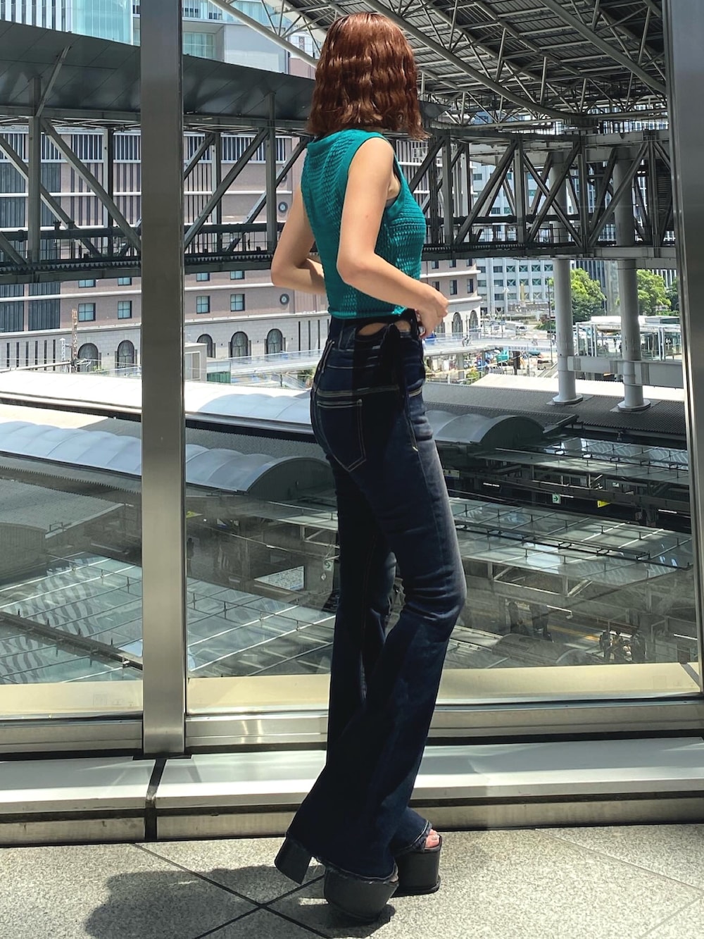 グリーン系のタンクトップ、ホワイト系のキャミソール、ブルー系のデニムパンツを着用したレディースの夏コーディネートの2枚目の写真