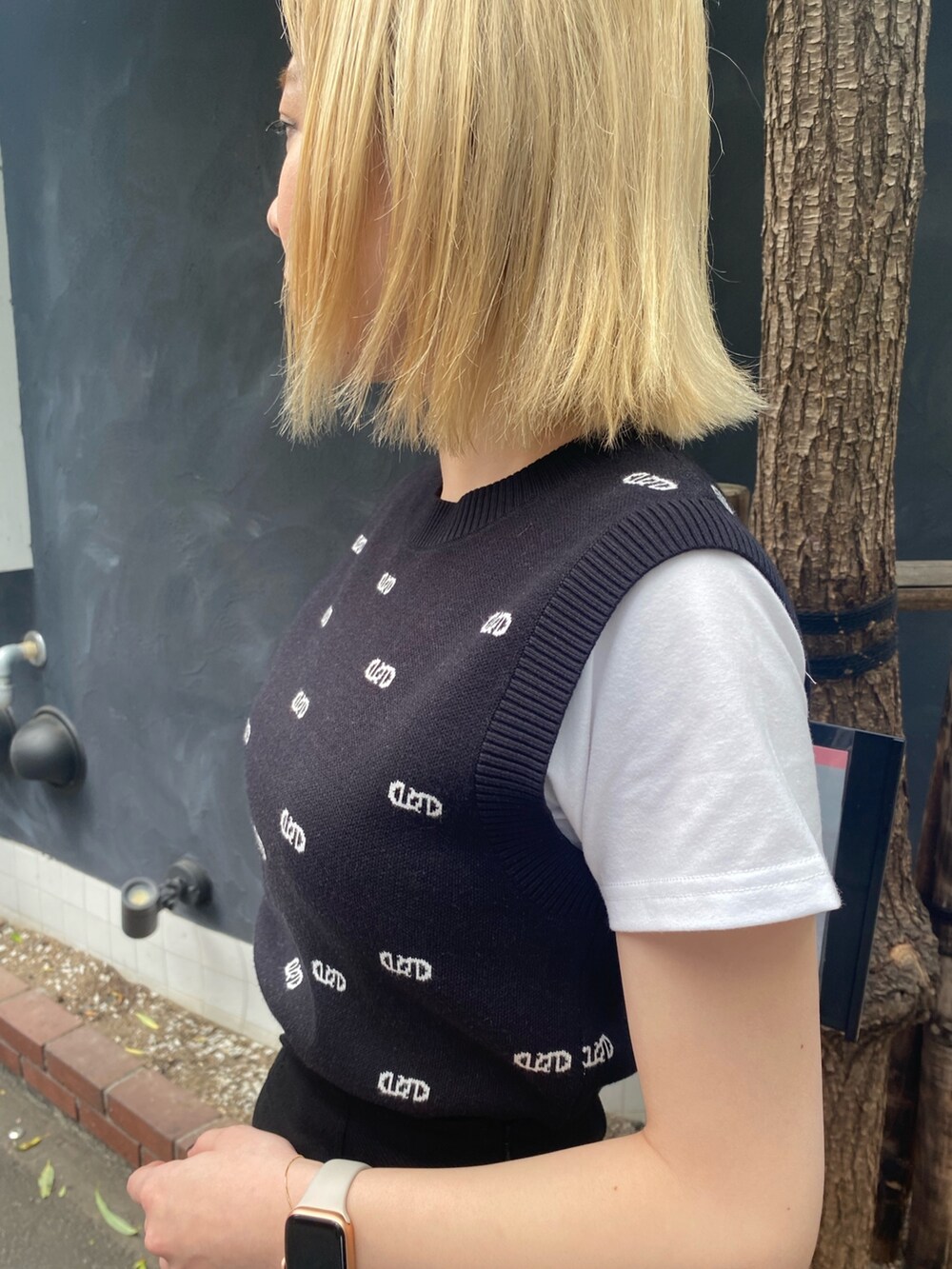 ブラック系のニット/セーター、ブラック系のスカート、ブラック系のサンダルを着用したレディースの春コーディネートの3枚目の写真