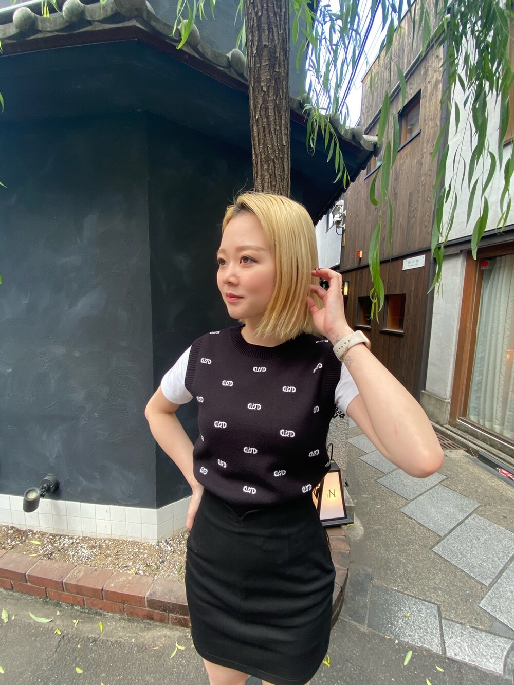 ブラック系のニット/セーター、ブラック系のスカート、ブラック系のサンダルを着用したレディースの春コーディネートの2枚目の写真