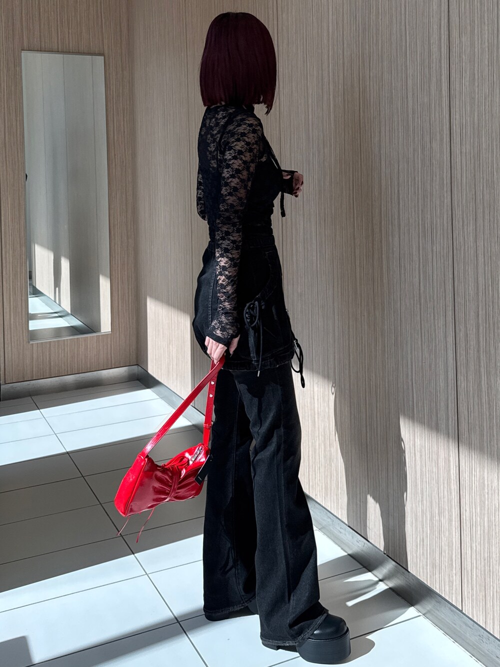 ブラック系のTシャツ/カットソー、ブラック系のデニムパンツ、レッド系のショルダーバッグを着用したレディースの秋コーディネートの2枚目の写真