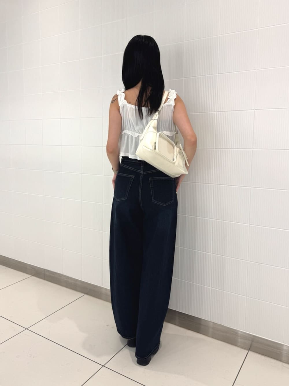 ブラック系のサンダル、ホワイト系のタンクトップ、ブルー系のデニムパンツを着用したレディースの夏コーディネートの3枚目の写真