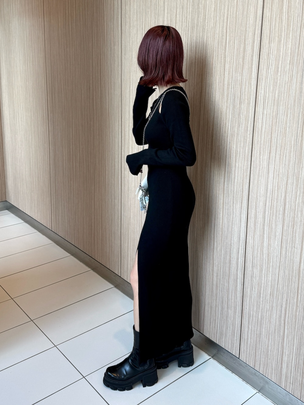 ブラック系のワンピース、ブラック系のブーツ、ホワイト系のスマホケース/カバーを着用したレディースの冬コーディネートの3枚目の写真