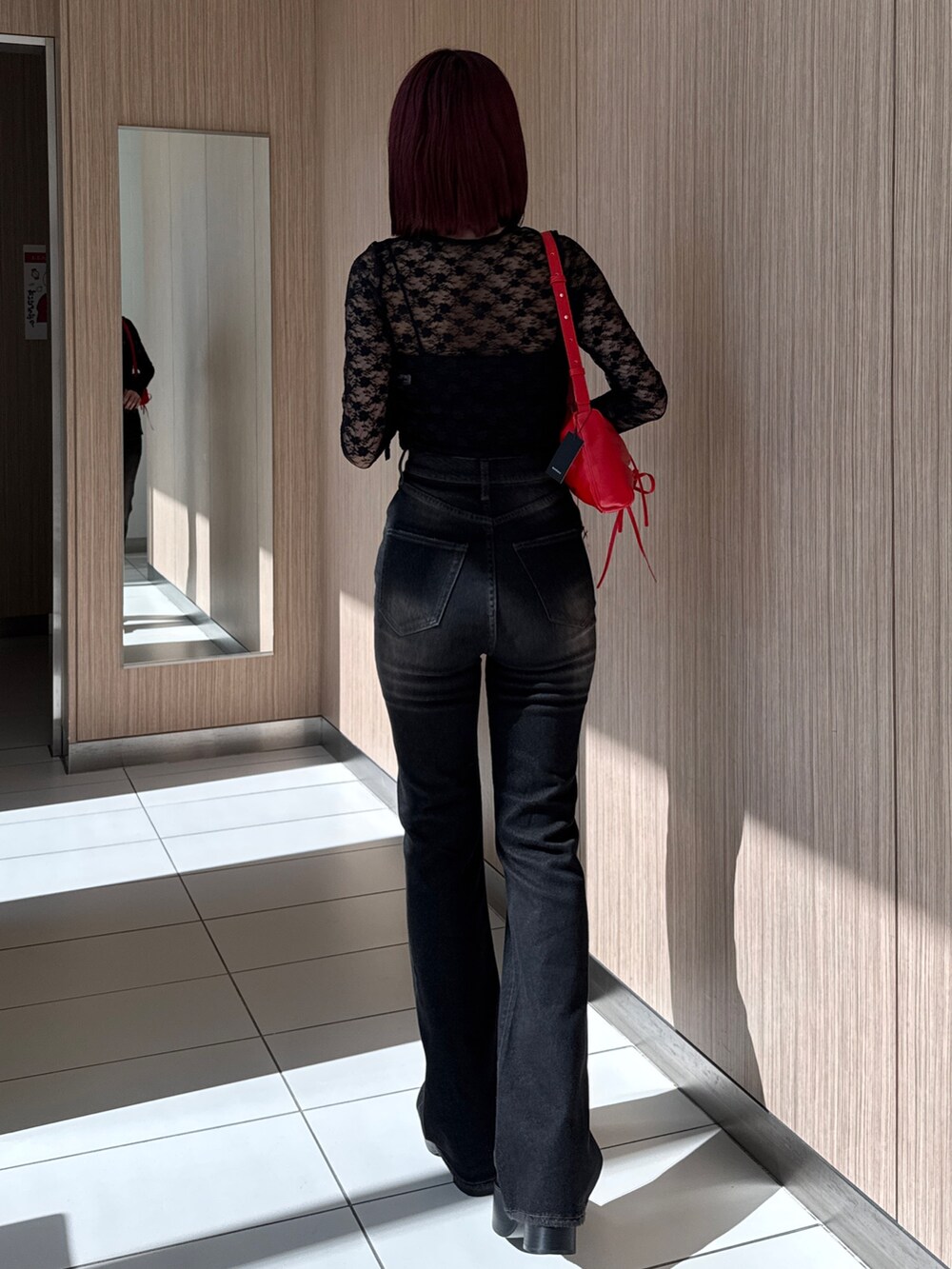 ブラック系のTシャツ/カットソー、ブラック系のデニムパンツ、レッド系のショルダーバッグを着用したレディースの秋コーディネートの7枚目の写真