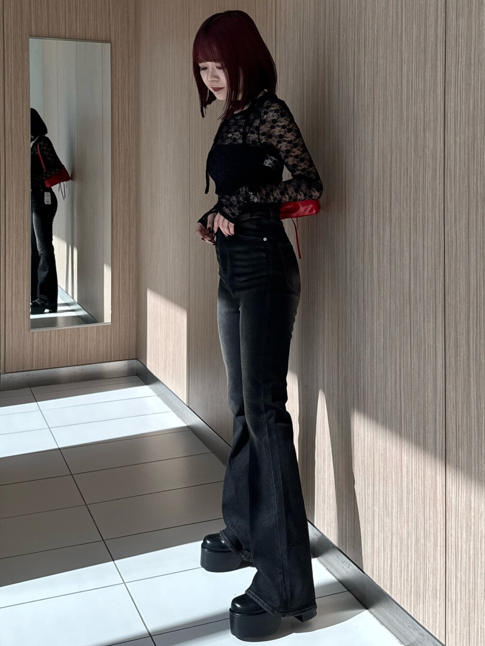 ブラック系のTシャツ/カットソー、ブラック系のデニムパンツ、レッド系のショルダーバッグを着用したレディースの秋コーディネートの6枚目の写真